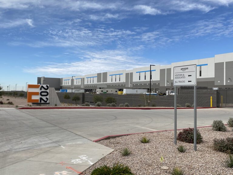 An industrial area with a modern warehouse offering civil engineering services and a sign indicating authorized vehicles only.