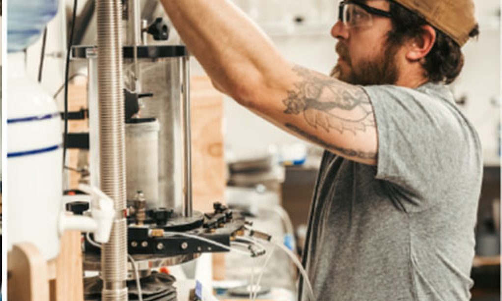 Man adjusting equipment in a Quality Testing LLC laboratory setting.